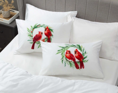 Angled view of our Cardinals Pillow Talk Pillowcases sitting on a white bed in a dark grey bedroom.