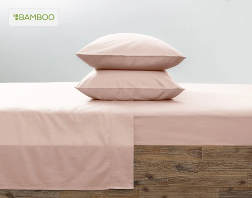 Two of our Bamboo Cotton Pillowcases in Blush Pink stacked on top of each other on a coordinating pink bed.