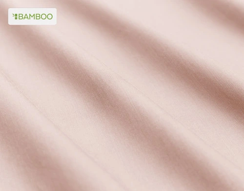 Gros plan sur le tissu doux bamboo cotton de notre Bamboo Cotton drap  ensemble  en rose blush rose légèrement ébouriffé.