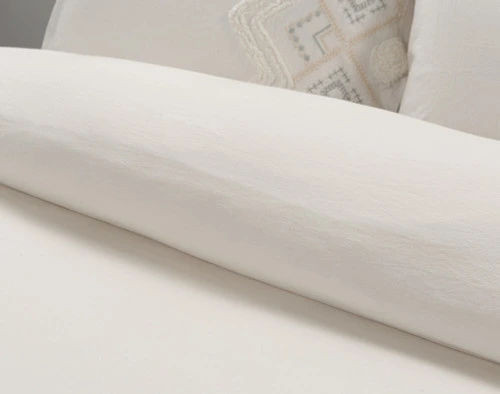 La housse de couette Charity se retourne en percale de coton 200TC blanc naturel.