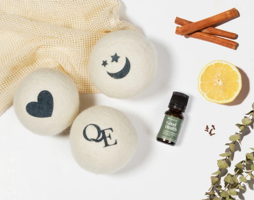 Les boules de séchage en laine Linen Love et l'amplificateur de parfum Good Health à côté de ses ingrédients (citron, cannelle et thym).