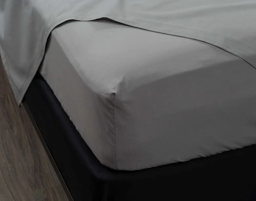 Coin de l'ajusté et du plat drap sur notre Percale de coton drap ensemble  en gris pour montrer son ajustement confortable.