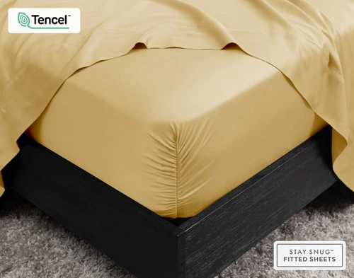 Vue d'angle de notre BeechBliss TENCEL™ Modal Fitted drap en Sun Shower sur fond blanc sur un matelas.