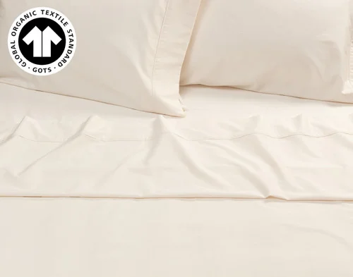 Front view of our Undyed & Unbleached Organic Cotton Sateen Pillowcases resting on a coordinating bed.