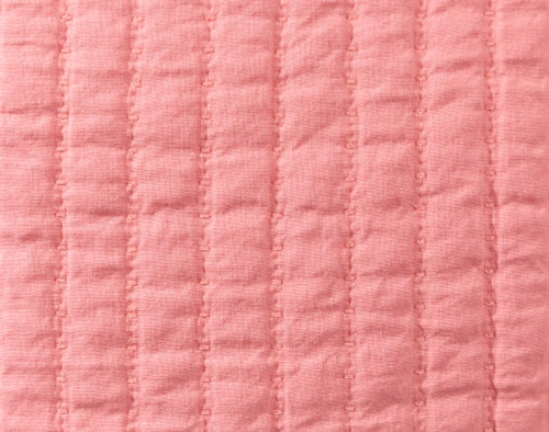 Gros plan sur les lignes matelassées texturées de notre housse de coussin carrée en lin et coton, coloris fuchsia.