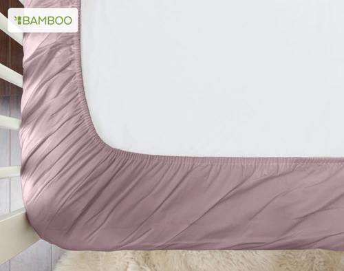 Vue du bas de notre Bamboo Cotton Crib-Sized Fitted drap en Orchid pour montrer son bord élastique.