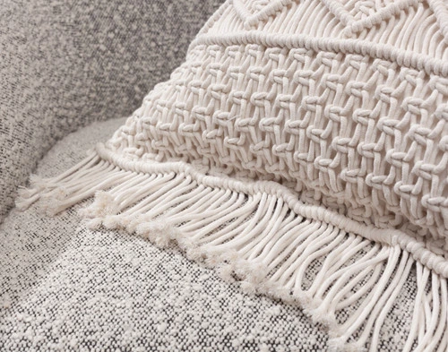 Gros plan sur les franges de corde sur le côté de notre housse de coussin carrée en macramé.