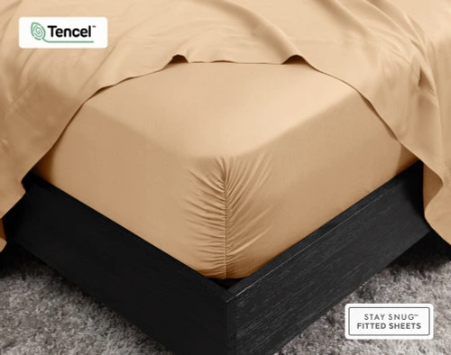 Gros plan sur le coin de notre BeechBliss TENCEL™ Modal Fitted drap en Cashew qui s'adapte parfaitement à un matelas avec un drap plat drapé sur le dessus.