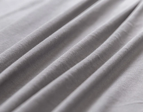 Gros plan sur la finition chinée et le tissu doux à volants de notre Bamboo Cotton Jersey drap ensemble  en gris.