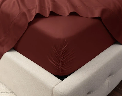 Gros plan sur le coin d'un matelas avec notre Eucalyptus Luxe TENCEL™ Lyocell Fitted drap en Maroon pour montrer qu'il est bien ajusté.