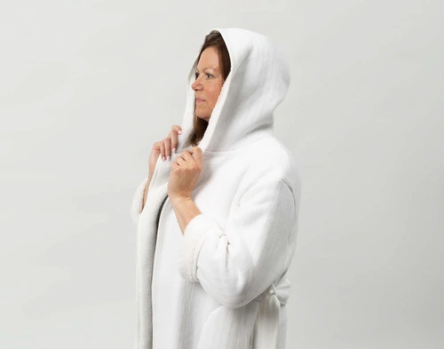 Woman wearing our White Chenille Sherpa Bathrobe with the hood pulled over her head.