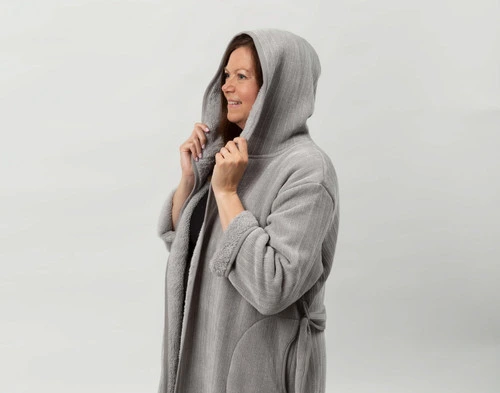 Woman wearing our White Chenille Sherpa Bathrobe with the hood pulled over her head.