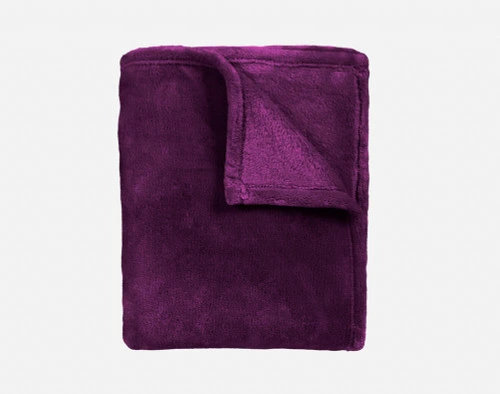 Notre Jeté Velvet Plush en violet se plie proprement en un carré bien rangé.