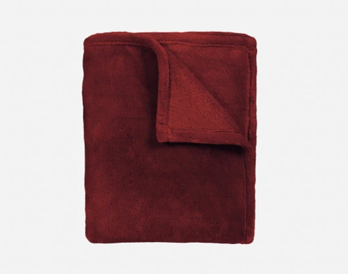 Notre Jeté Velvet Plush en Merlot se plie proprement en un carré bien rangé.