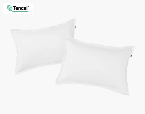 Vue de face de deux taies d'oreiller BeechBliss TENCEL™ Modal en blanc assises côte à côte sur un fond blanc uni.