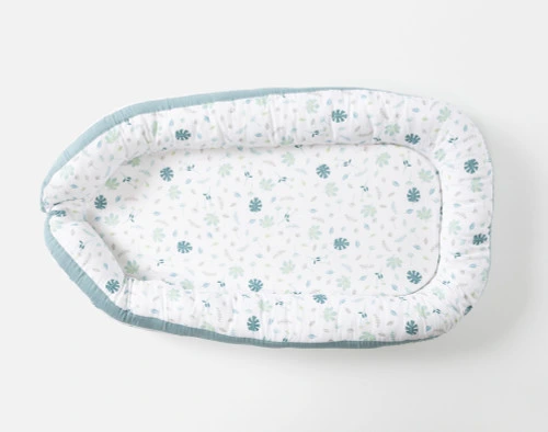 Top view of our Baby Nest Bed in Teal sitting on a solid white ground.