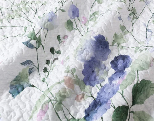 Close-up on the blue floral design on the surface of our Evelyn Coverlet Set.