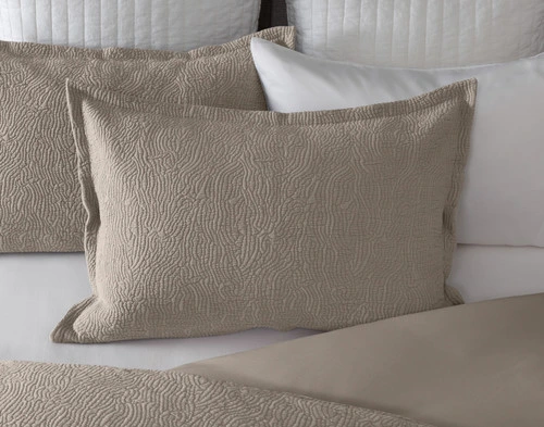 Front view of our Brava Pillow Sham sitting over a solid white bed with coordinating pillow shams.