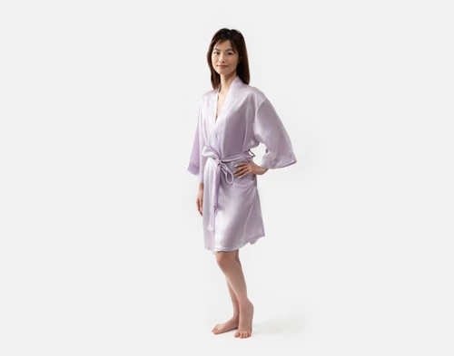 Notre robe kimono en soie lavande est portée par une jeune femme à la silhouette élancée.