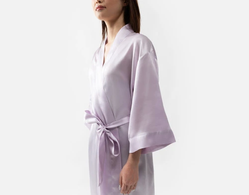 Vue latérale de notre robe kimono en soie lavande portée par une jeune femme.