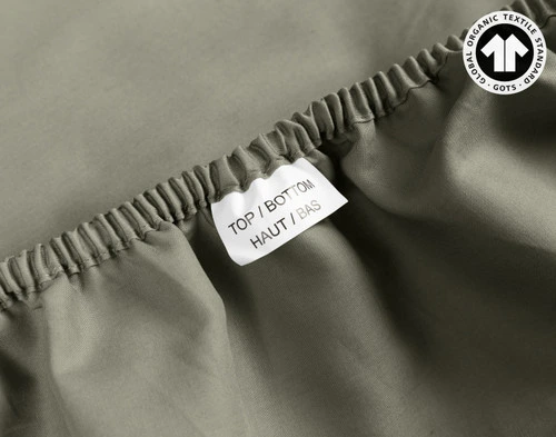 Close-up on a tag reading Top & Bottom on the edge of our Organic Cotton Fitted Sheet in Alligator.