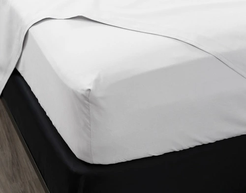 Close-up of the corner on our White Organic Cotton Percale Fitted Sheet stretched over a short mattress.