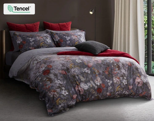 Angled view of our Renoir Floral Duvet Cover over a modern queen bed with coordinating red and grey accessories.