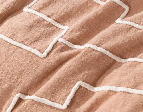 Close-up of the textural terracotta surface and white chenille appliqué tufting of our Canyonlands Duvet Cover.