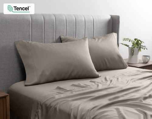 Front view of our BeechBliss TENCEL™ Modal Pillowcase in Grey Oak resting against a headboard in a bed with matching sheets.