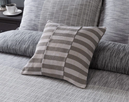 Angled view of our Halston Square Cushion Cover sitting over a coordinating duvet cover.