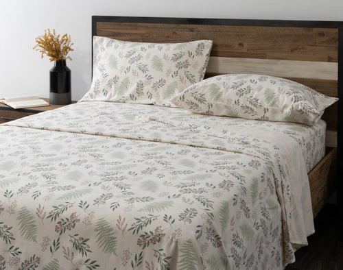 Angled view of our Festive Foliage Organic Flannel Cotton Sheet Set dressed over a plain queen bed.