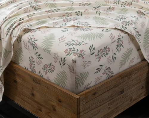 Gros plan d'un coin de matelas habillé d'un drap ajusté de notreensemble drap  coton flanelle biologique Festive Foliage, avec un drap plat par-dessus.