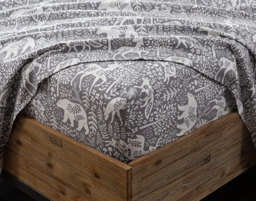 Gros plan sur un coin de matelas habillé d'un drap  ajusté de notreensemble Enchanted Woodlands Organic Flannel Cotton, avec un drap plat par-dessus.