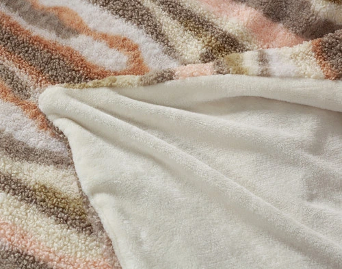 Folded corner of our Clay Terra Nova Throw to show its cream beige plush-like backing.