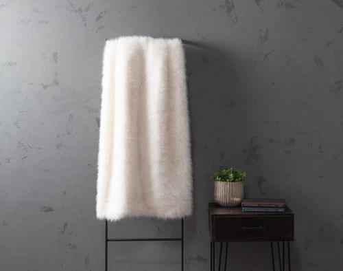 Front view of our ______ Arctic Fox Throw hanging vertically on a tall wall rack.