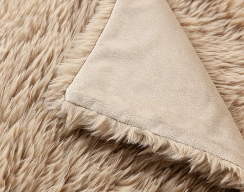 Close-up of the folded corner on our Oat Soft Mink Throw to show its smooth underside and fluffy surface.