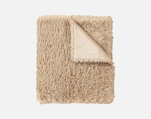 Top view of our Oat Soft Mink Throw folded into a tidy square in a white room.