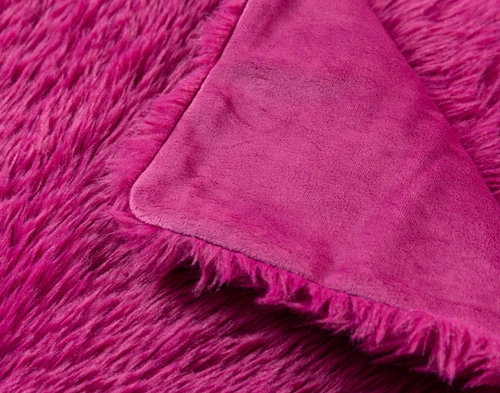 Top view of our Fuchsia Soft Mink Throw folded into a tidy square in a white room.