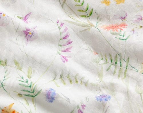 Close up of the Lena Duvet Cover design with playful colourful flowers on a diamond dobby weave.