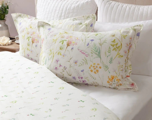 Two Lena Pillow Shams at the head of a bed dressed with the matching Lena Duvet Cover reversed to its coordinating side with smaller flowers.