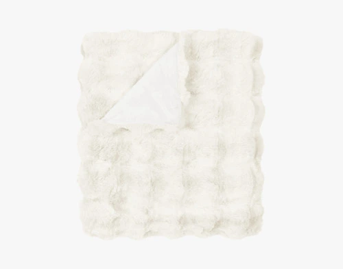 Our Bubble Faux Fur Throw in White folded into a tidy square against a solid white background.