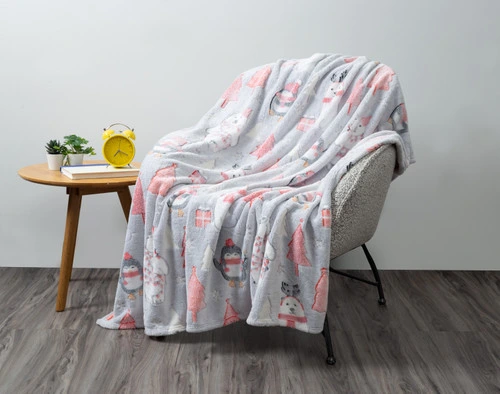 Our Polar Festivities Glow in the Dark Fleece Throw draped over an armchair in an empty grey living room.