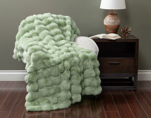 Front view of our Green Bubble Faux Fur Throw draped over a small armchair in a green fall living room.