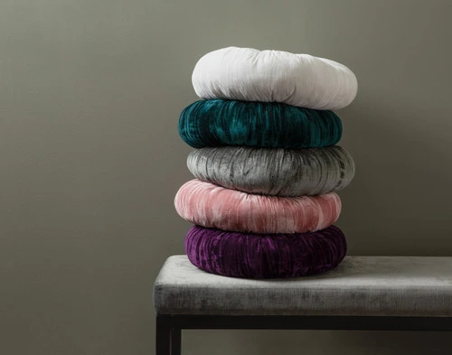 Side view of our Pleated Velvet Round Cushions in all five colours stacked atop each other.