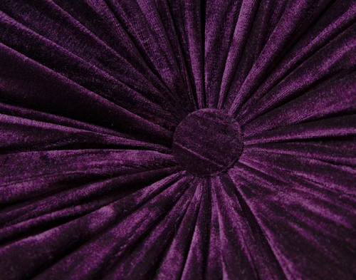 Gros plan sur la surface en velours et le détail du bouton au centre de notre coussin rond en velours plissé violet.