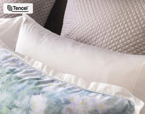 Close up on our Persuasion Pillow Sham decorating the head of a bed with accessories.