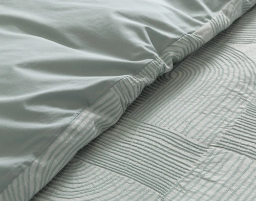 Close up of the Tempo Duvet Cover, folded to show its main and reverse coordinating sides.