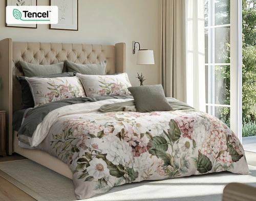 Our Positano Floral Duvet Cover dressed in a sunlit bedroom with olive green sheeting and accessories.