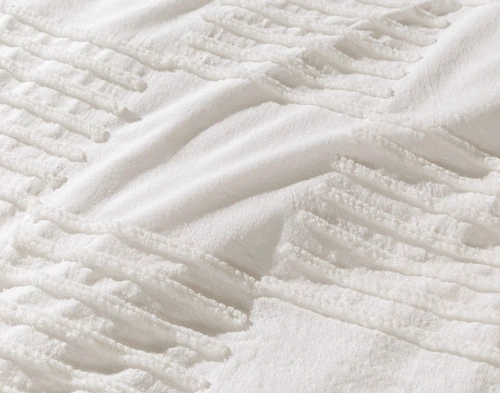 Close-up of the solid and tufted squares on the surface of our Caro Duvet Cover.