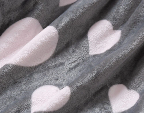 Close up of the Blushing Hearts Fleece Throw, showcasing the soft texture and pink and grey hearts design.